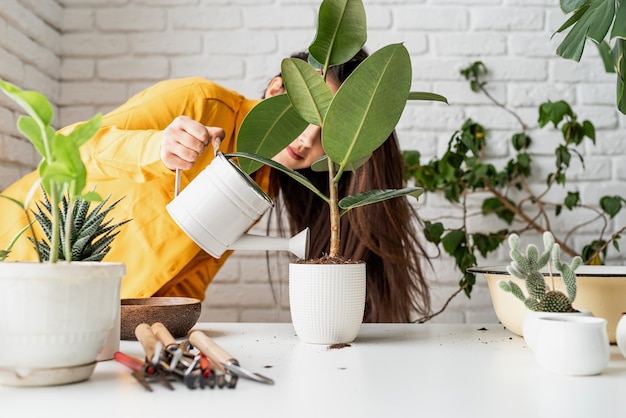 Foto jardineira com roupas amarelas cuidando das plantas