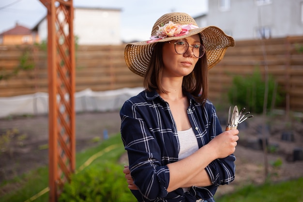 Foto jardineira de retrato de mulher com chapéu trabalhando no jardim no quintal