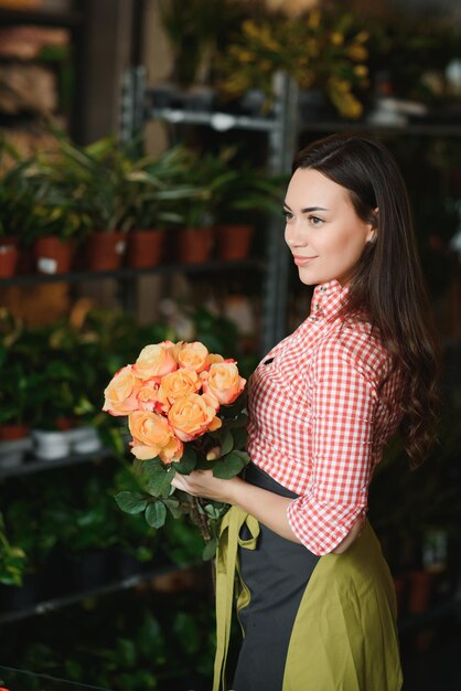 Foto jardineira feliz na loja de flores faz bouquets para uma loja de flores de estilo de vida de férias