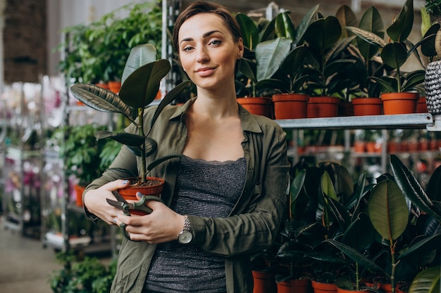 Jardineira feminina na casa da planta com plantas e flores