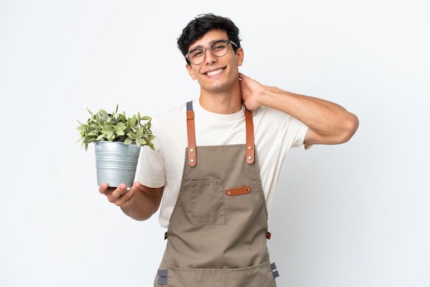 Jardineiro argentino segurando uma planta isolada no fundo branco rindo