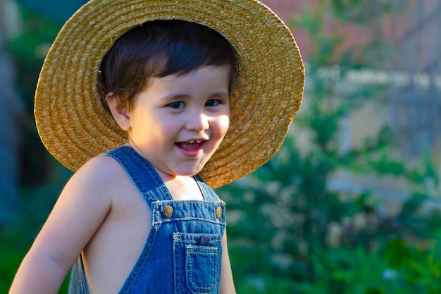 jardineiro bebê sorrindo brincalhão com seu chapéu