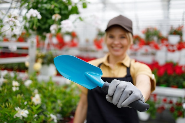 Jardineiro feminino mostrando uma espátula de mão