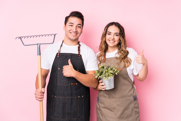 Jardineiro jovem casal sorrindo e levantando o polegar