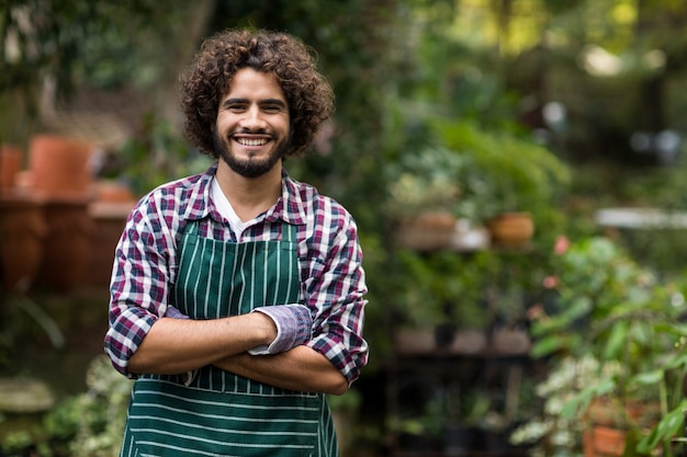 Jardineiro masculino confiante em pé na estufa