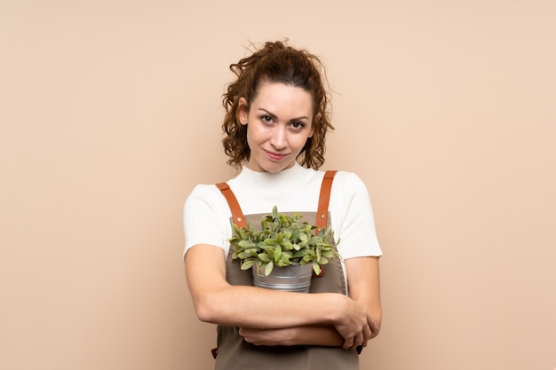 Foto jardineiro mulher segurando uma planta