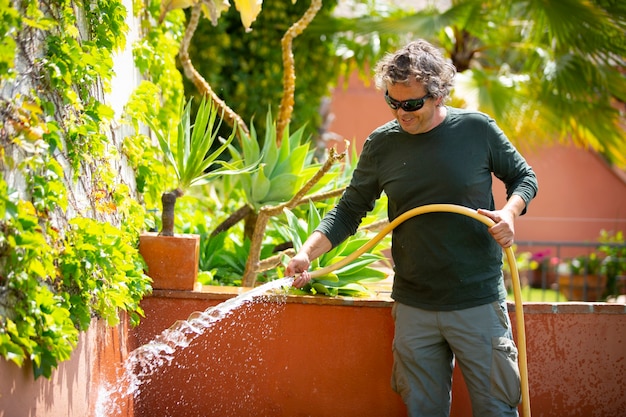 jardineiro regando plantas em um dia ensolarado