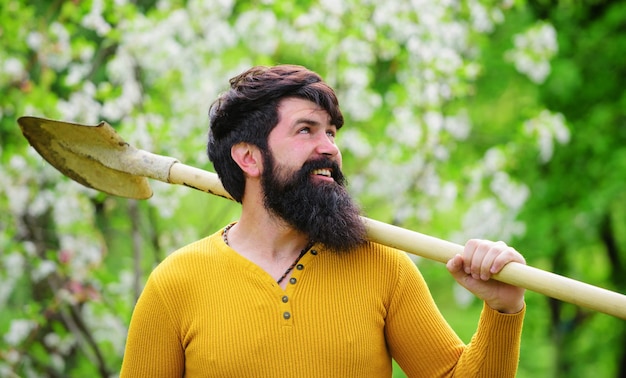 Jardineiro sorridente com agricultor de pá com pá trabalhando no jardim primavera trabalho plantando plantas