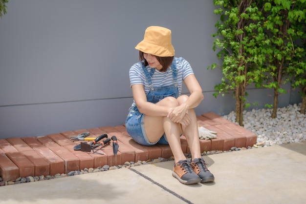 Una jardinera asiática está feliz con su trabajo