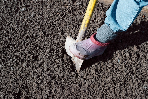 Jardinería preparación del suelo para sembrar Jardinero cavando tierra con pala en la granja al aire libre Vista lateral de cierre