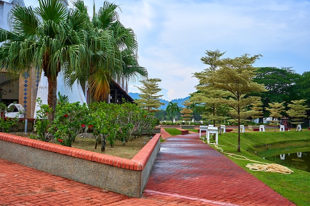 El jardinero apartó una manguera para regar las plantas en el césped del parque.