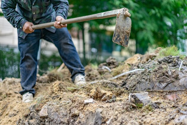 El jardinero cava el suelo con su equipo de jardinería y prepara la tierra para la plantación