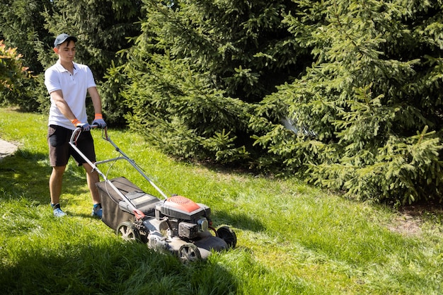 Jardinero cortando el césped con cortadora de césped de gasolina