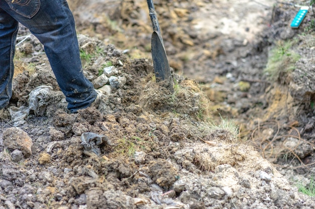 El jardinero excava la tierra con su equipo para la jardinería y prepara la tierra para la plantación.