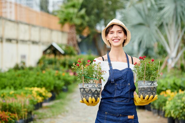 Jardinero feliz mostrando flores florecientes