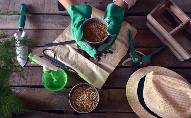 Jardinero haciendo trabajos de jardinería en una mesa rústica.