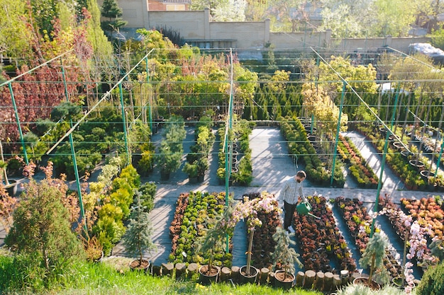 Jardinero hipster trabajando en el jardín de la ciudad