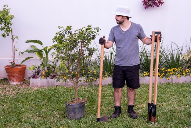 Jardinero en el jardín con herramientas para plantar un árbol.