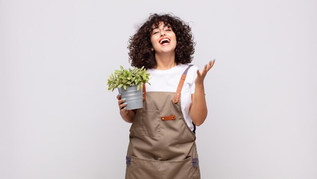 Jardinero joven que se siente feliz, sorprendido y alegre, sonriendo con actitud positiva, dándose cuenta de una solución o idea