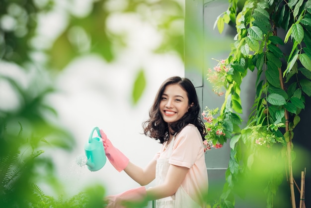 Jardinero mujer asiática joven regando las plantas