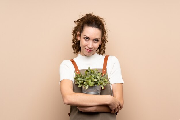 Jardinero mujer sosteniendo una planta