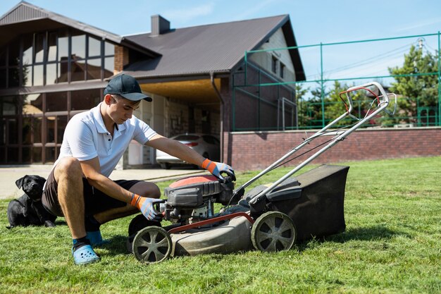 El jardinero prepara la cortadora de césped para arrancar el motor.