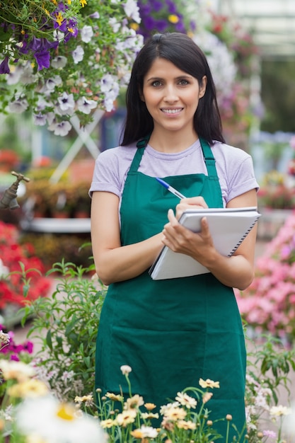 Jardinero tomando notas en el centro de jardinería