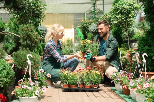 Jardineros trabajando con flores en el centro de jardinería