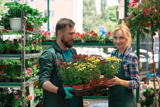 Jardineros trabajando con flores en el centro de jardinería