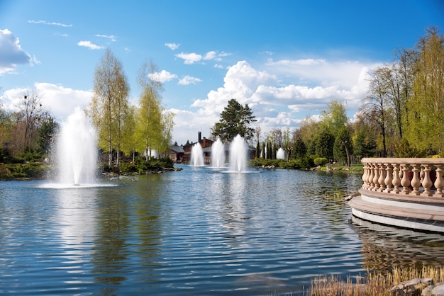 Jardines ornamentales con lago, arbustos florecientes y fuente