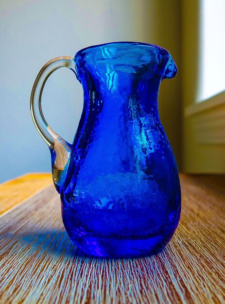 Foto una jarra azul en la mesa.