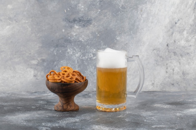 Foto jarra de cerveza y bocadillos en la superficie de piedra