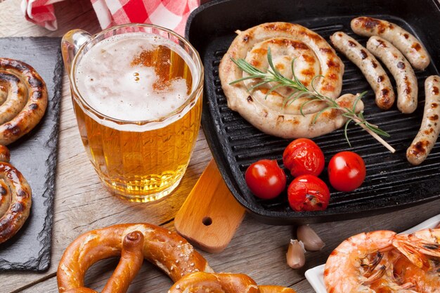 Jarra de cerveza camarones a la parrilla salchichas y pretzel