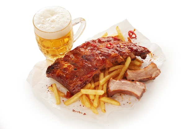 Jarra de cerveza y costillas de cerdo en la mesa