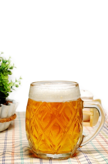 Jarra de cerveza ligera en una mesa en el pub o café con fondo blanco.