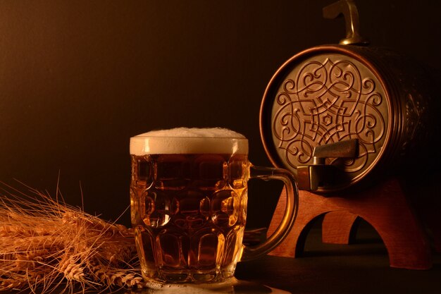 Jarra de cerveza y trigo y pescado seco sobre fondo oscuro