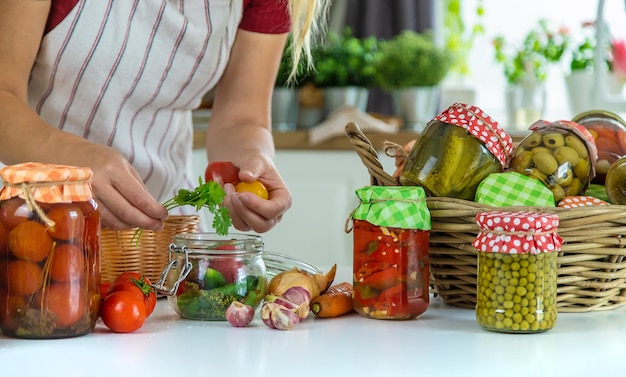 Jarra de mulher preserva legumes na cozinha Foco seletivo