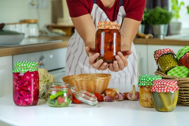 Jarra de mulher preserva legumes na cozinha Foco seletivo