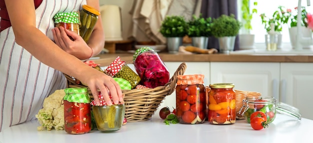 Jarra de mulher preserva legumes na cozinha Foco seletivo