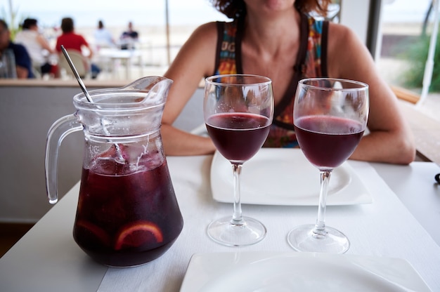 Jarra de sangria com dois copos em um terraço na praia