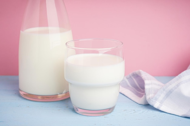 Foto jarra e copo de leite fresco sobre um fundo colorido