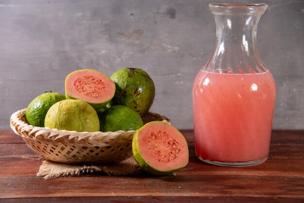 Foto una jarra de jugo de guayaba en una mesa de madera rústica