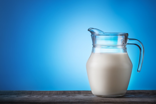 Jarra con leche en la mesa de madera