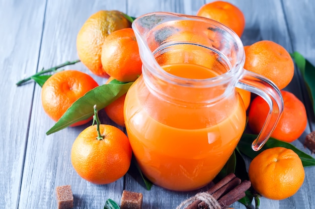 Jarra llena de jugo de mandarina con mandarinas