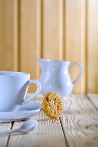 Jarra y taza de café azul sobre mesa blanca