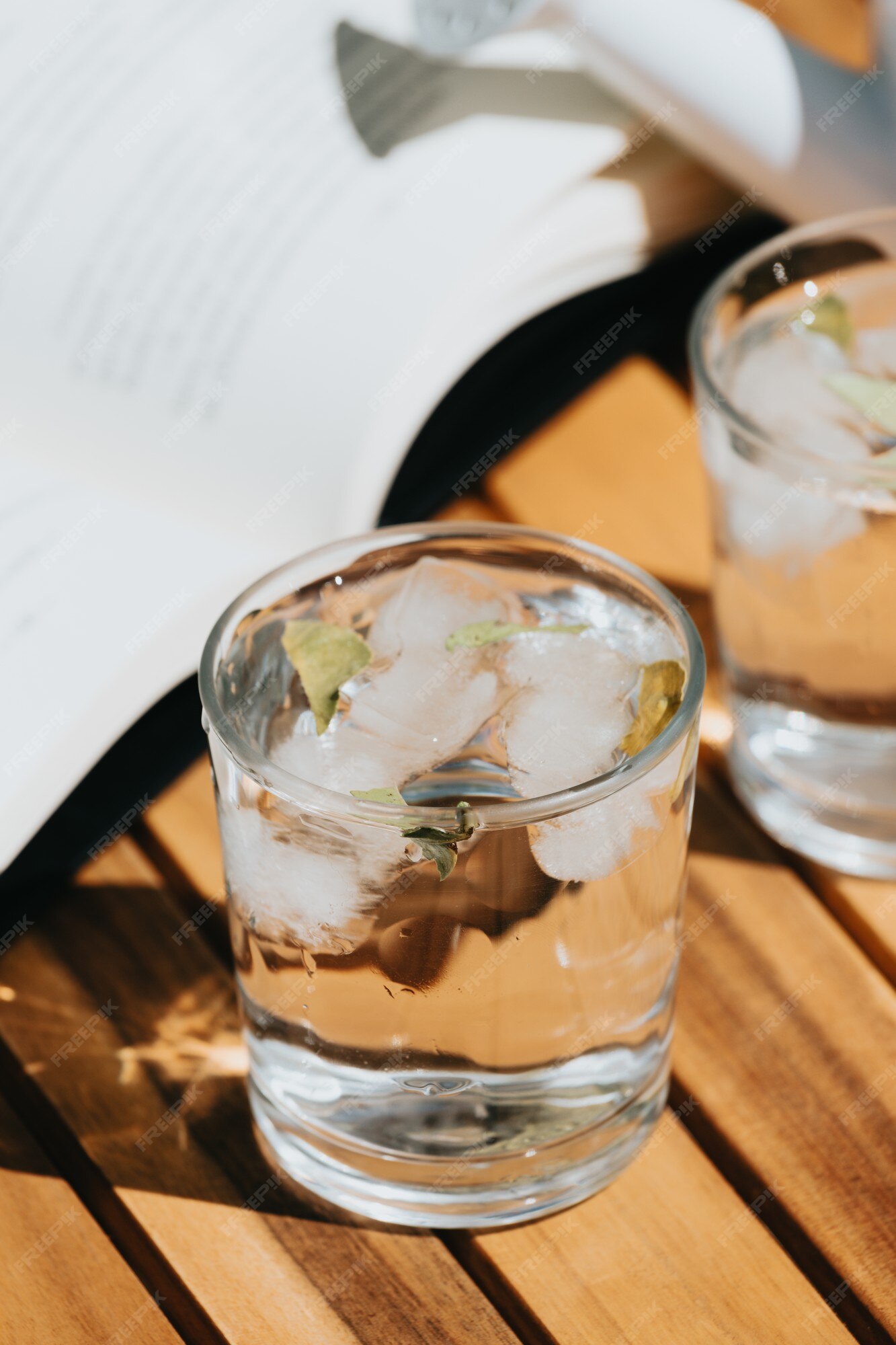 Vaso y una jarra de agua sobre la mesa de madera