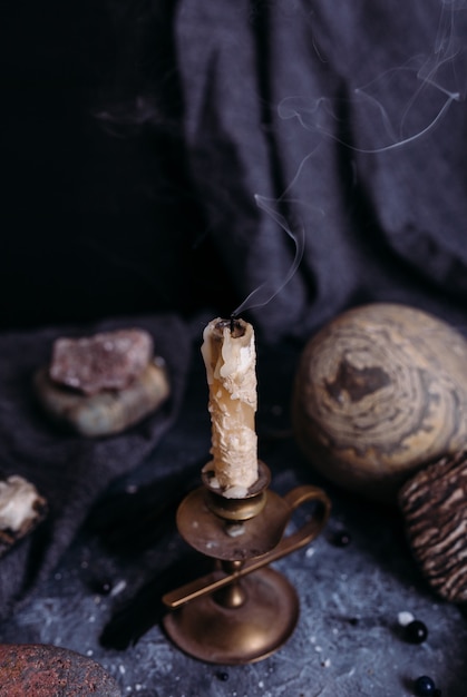 Foto jarra de velas apagadas y piedras sobre la mesa de brujas