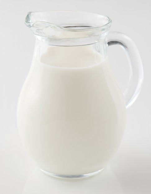 Jarra de vidrio de leche fresca aislada en blanco