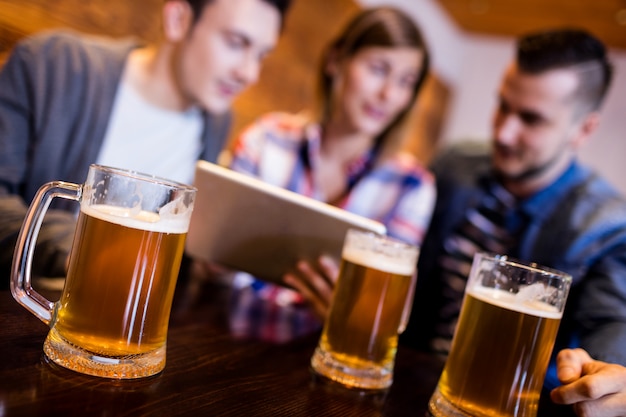 Jarras de cerveza con amigos en el restaurante