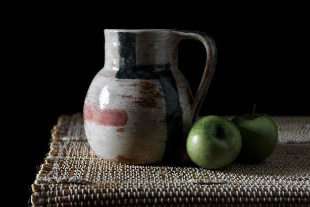 Jarro de cerámica y manzana verde